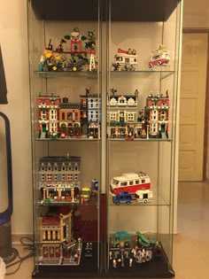 a display case filled with lots of toy vehicles and legos on top of glass shelves