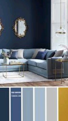 a living room with blue walls and gold accents in the color scheme, along with two mirrors on the wall