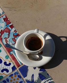 a cup of coffee sitting on top of a white saucer