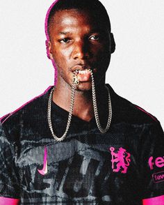 a man with chains on his mouth wearing a black shirt and pink trimmings