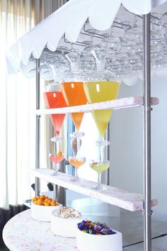 the drinks are lined up on the shelf for consumption to be served at an event