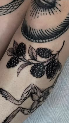 a woman's legs with blackberries and leaves on the side of her leg