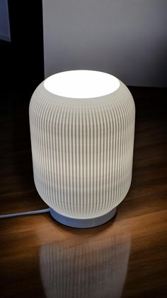 a white lamp sitting on top of a wooden table