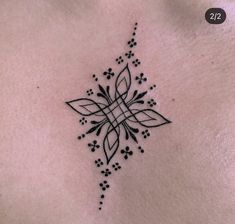 a black and white photo of a woman's chest with a tattoo design on it