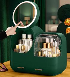 a person holding a magnifying glass in front of a green display case filled with cosmetics