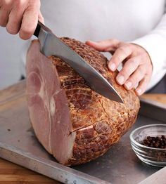 a person cutting meat with a large knife