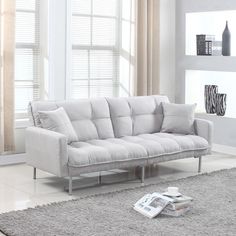 a living room with white furniture and large windows