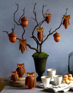 there are many owls on the tree with cups and saucers in front of them