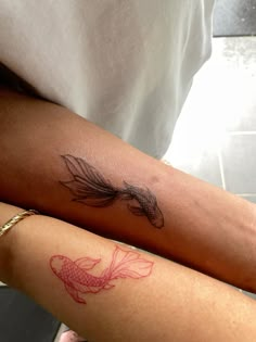 two people with tattoos on their arms, one has a goldfish and the other has a red fish