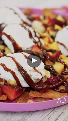 a pink plate topped with waffles covered in ice cream and strawberries on top