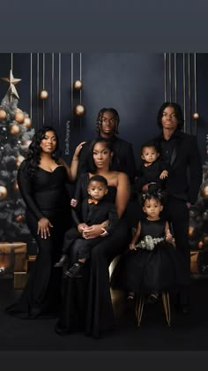 a family posing for a christmas photo in front of a christmas tree