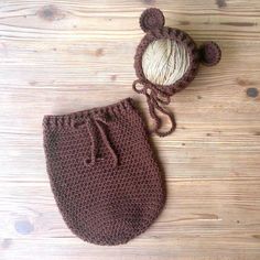 a crocheted hat and diaper cover sitting on top of a wooden floor