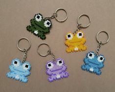 four pixel keychains with different designs on them