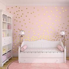 a pink and gold girls'room with polka dot decals on the wall, white daybed in foreground