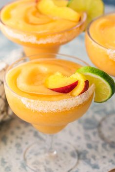 three glasses filled with drinks and topped with fruit