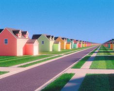 a row of colorful houses sitting next to each other on a green grass covered field