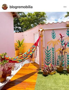 a hammock in the middle of a backyard with potted plants and other decorations