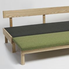 a bench made out of wood and fabric with green cushions on it's sides