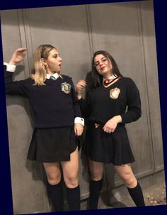 two women dressed in school uniforms posing for the camera