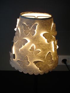 a lamp that has some butterflies on the inside of it, and is lit up