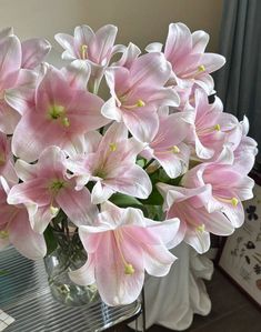 a vase filled with pink flowers on top of a table