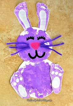 a purple bunny made out of paper on a brown surface with white dots and pink nose