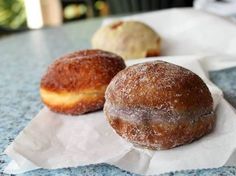 two donuts sitting on top of a piece of wax paper