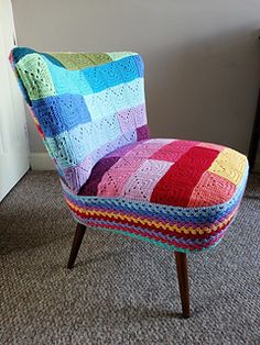 a multicolored crocheted chair sitting in front of a door