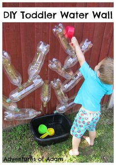 a young boy playing with an inflatable water bottle tree