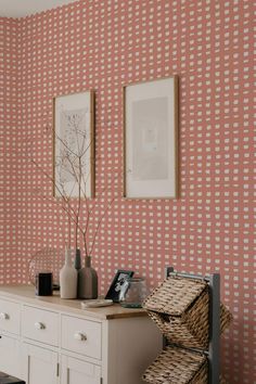 two vases are sitting on a dresser in front of a wallpapered room