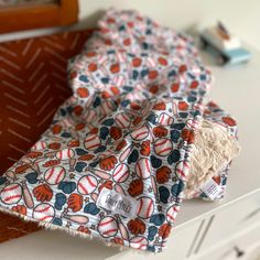 two pieces of cloth with baseballs on them sitting on top of a white table