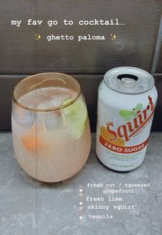 a can of soda next to a glass filled with fruit