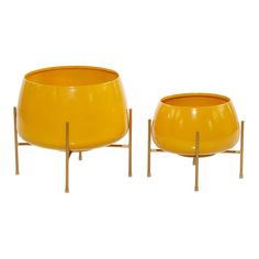 two yellow planters sitting next to each other on metal stands, one is empty