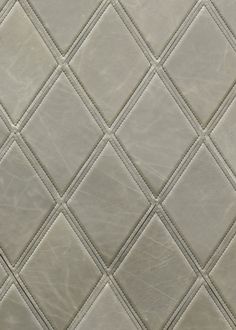 a close up view of a white leather textured wallpaper with diamond patterning