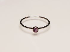 Looking for a dainty and stackable June birth stone ring? This ring is the perfect best friend gift, gift for your sister, or dainty jewelry for your bridesmaids to wear on your wedding day, pick any one of our 12 birthstone choices! Product Details: Materials: Stainless Steel Color: Silver Stone Color: Purple Band Size: 1mm Stone Size: 3mm You will receive one June birthstone ring. Adjustable Rose Gold Sterling Silver Birthstone Ring, Dainty Birthstone Midi Rings For Gifts, Dainty Adjustable Stackable Rings, Adjustable Minimalist Birthstone Ring With Gemstone, Dainty Adjustable Birthstone Ring With Round Stone, Delicate Adjustable Birthstone Ring For Everyday, Adjustable Minimalist Birthstone Ring With Round Stone, Minimalist Adjustable Birthstone Crystal Ring, Minimalist Adjustable Crystal Ring With Birthstone