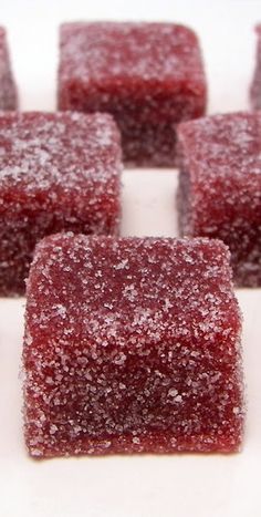 several squares of red colored sugar on a white surface