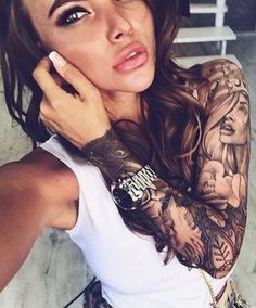 a woman with tattoos on her arm holding a cell phone