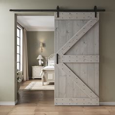 an open barn door in a bedroom with hardwood floors