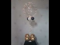 a black and white clock with gold balloons hanging from it's sides on a wall