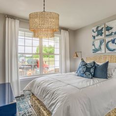 a bedroom with white bedding, blue and gold decor and pictures on the wall