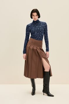 This chocolate brown midi skirt offers a sophisticated yet modern twist on a classic design. Crafted from a luxurious blend of viscose and virgin wool, the skirt features sharp pleats that create a structured silhouette, adding both movement and depth. The high-waisted fit is designed to flatter your figure, while the thigh-high slit introduces a touch of contemporary flair. 79% Viscose, 21% Virgin Wool  Dry clean only Brown Midi Skirt, Tailored Skirt, Gifts For New Mums, Pearl Jewellery Earrings, Pleated Midi Skirt, August Birth Stone, Sustainable Fabrics, Independent Designers Fashion, Jacket Sale