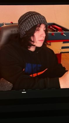 a young man sitting in front of a laptop computer