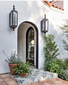 the front entrance to a house with potted plants