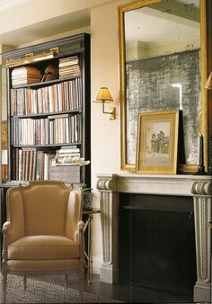 a living room filled with furniture and a fire place in front of a book shelf