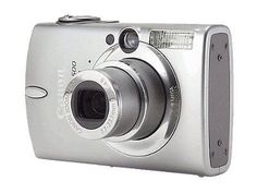 a silver digital camera sitting on top of a white surface