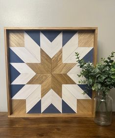 a wooden frame with a flower and vase on a table