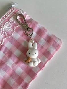 a pink and white checkered cloth with a keychain shaped like a bunny