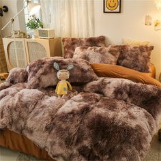 a bed covered in fluffy brown fur with a stuffed animal on the bottom and side