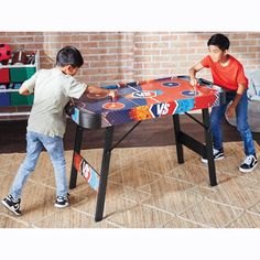 two young boys playing with a table top game