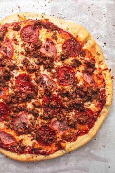 a pizza sitting on top of a table covered in toppings